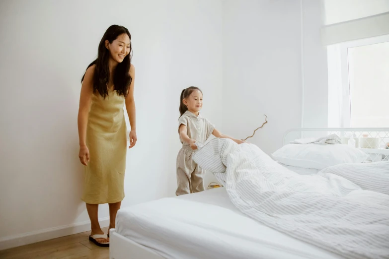 a woman standing next to a child on a bed, pexels contest winner, minimalism, japanese collection product, zeen chin and terada katsuya, clean design, gold