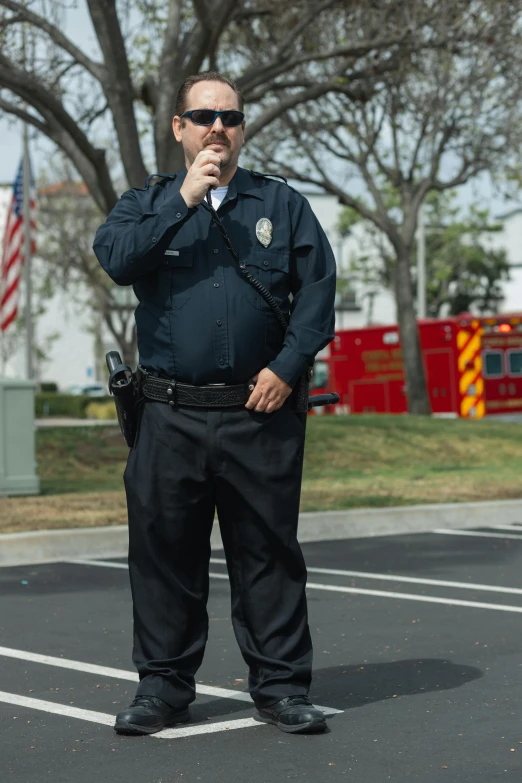 a man standing in a parking lot talking on a cell phone, officers uniform, holding a microphone, riverside, promo image