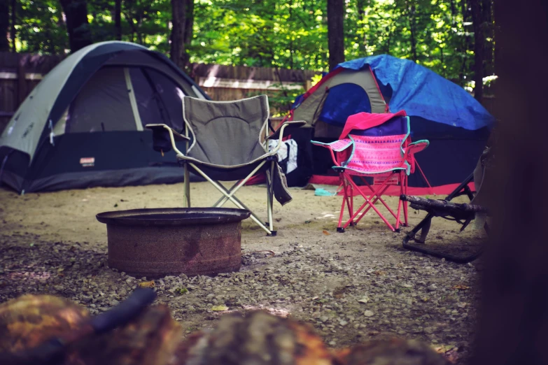 a couple of chairs sitting next to a fire pit, pexels contest winner, tents, william penn state forest, lo fi, tickle fight in the death tent