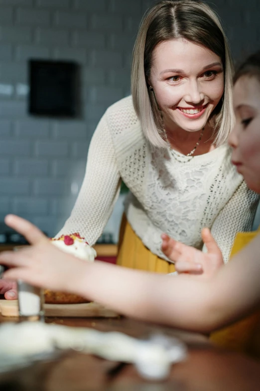 a woman and two children sitting at a table, trending on pexels, cake in hand, full frame image, digital image, baking artwork