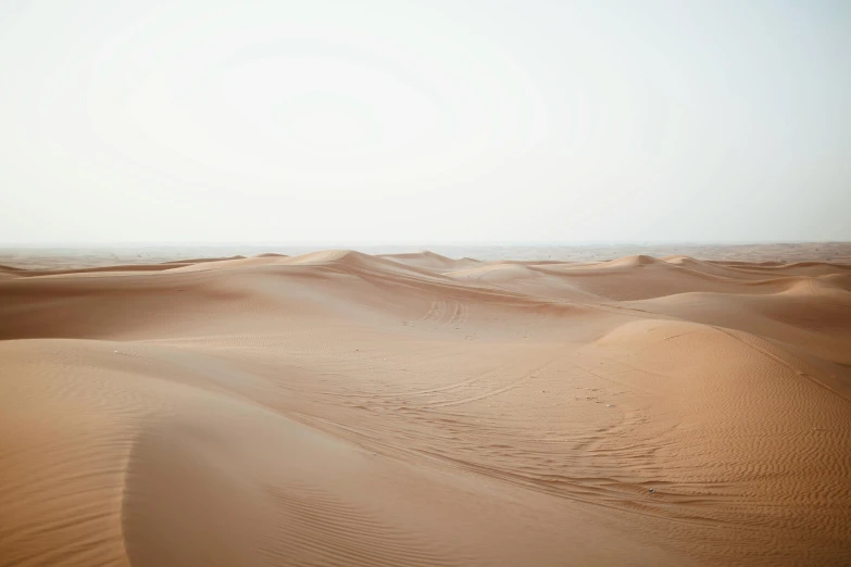 a person riding a horse in the desert, by Daniel Lieske, visual art, minimalist photo, sandy beige, islamic, colour photograph