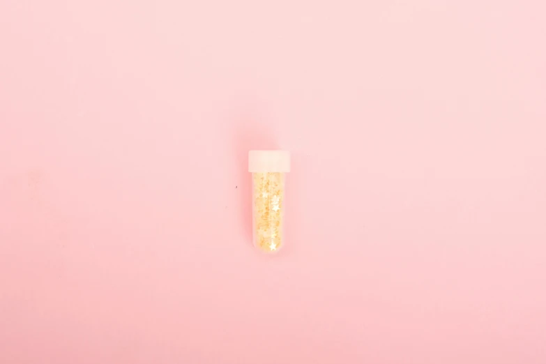 a tube of toothpaste on a pink background, by Ellen Gallagher, conceptual art, unrefined sparkling gold nugget, glitter gif, miniature product photo, light yellow