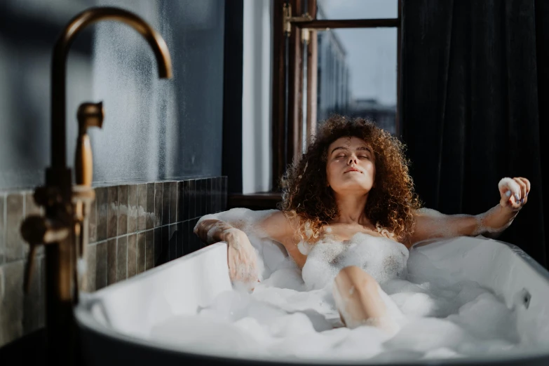 a woman taking a bubble bath in a bathtub, trending on pexels, renaissance, curly haired, sexy :8, relaxing after a hard day, cosy vibes