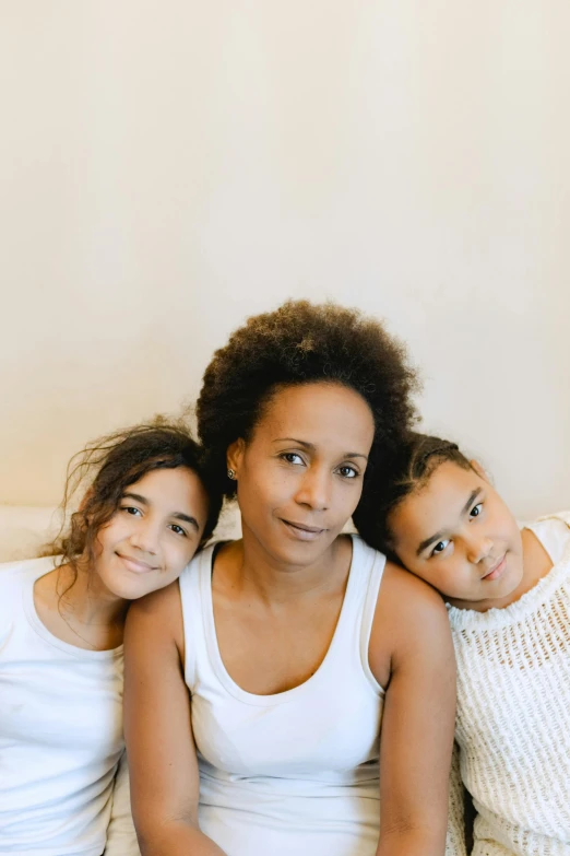 three women sitting next to each other on a couch, by Lily Delissa Joseph, pexels contest winner, incoherents, portrait of family of three, with brown skin, bedhead, mixed-race woman