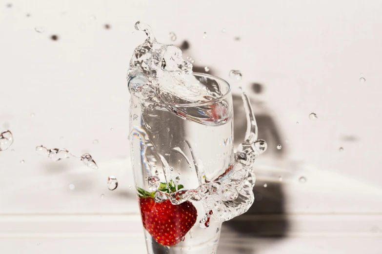 a strawberry splashing into a glass of water, unsplash, shot on sony a 7, sparkling, high quality photo, dynamic angled shot