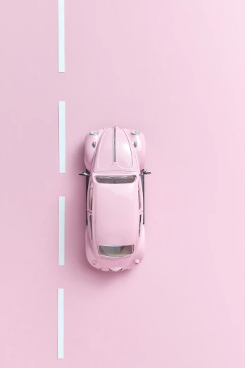 a pink toy car sitting on top of a road, inspired by Harry Haenigsen, unsplash contest winner, postminimalism, beetle, looking down from above, clemens ascher, 15081959 21121991 01012000 4k