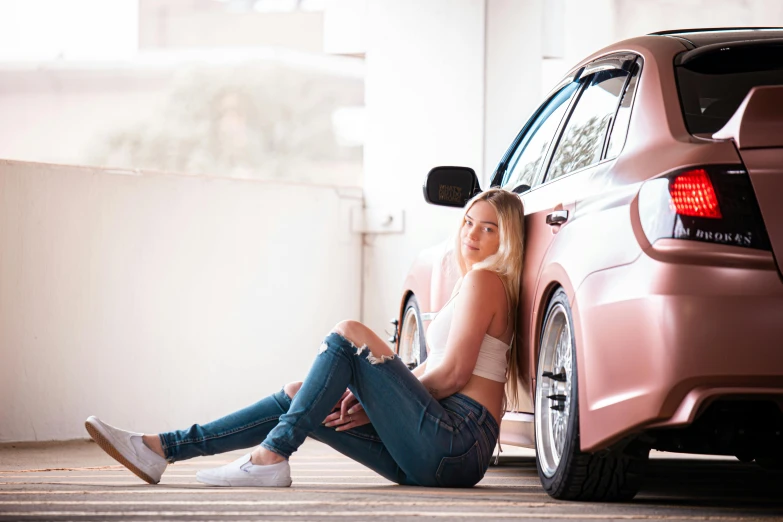a woman sitting on the ground next to a car, inspired by Sydney Carline, pexels contest winner, smooth pink skin, profile image, blonde, epic stance