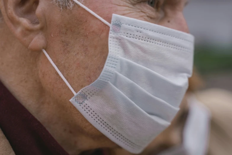 a close up of a person wearing a face mask, pexels contest winner, older male, over the shoulder view, white muzzle and underside, surgical supplies