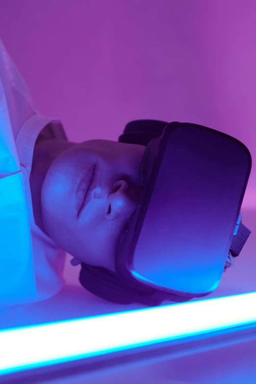 a man laying on a bed wearing a vr headset, a hologram, by Adam Marczyński, trending on unsplash, massurrealism, glowing pink face, hibernation capsule close-up, suspended in zero gravity, medical imaging