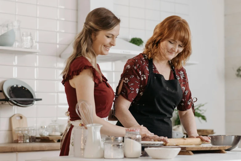 a couple of women standing next to each other in a kitchen, trending on pexels, art nouveau, ingredients on the table, covered in white flour, cooking show, aussie baristas