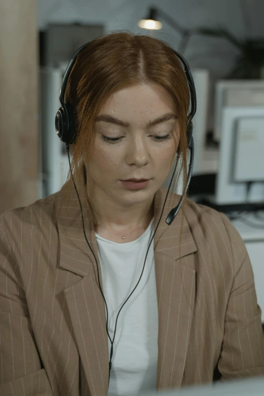 a woman sitting in front of a computer wearing headphones, eleanor tomlinson, multiple stories, professional image, wrinkly