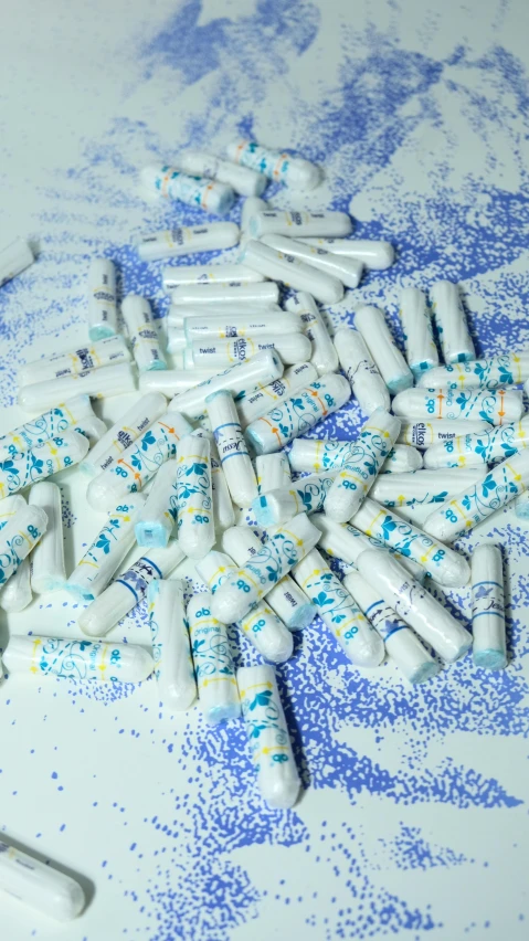 a pile of pills sitting on top of a table, inspired by Howardena Pindell, pexels, pointillism, white and blue, discarded scrolls, pool tubes, performance