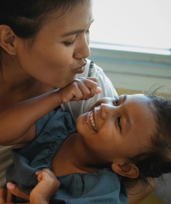 a woman holding a small child in her arms, pexels contest winner, happening, closeup. mouth open, south east asian with round face, profile image, thumbnail