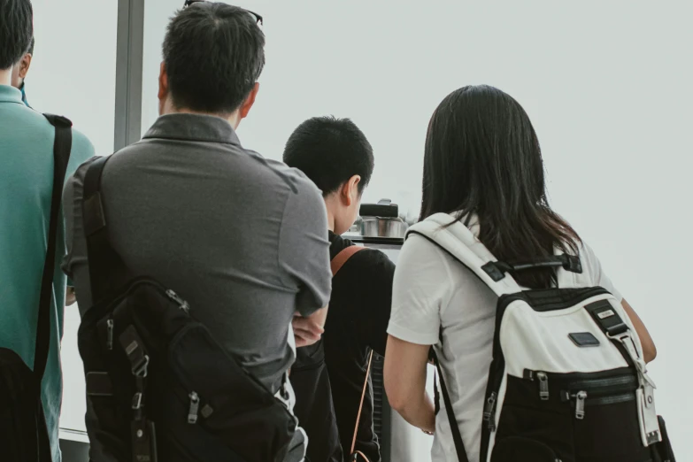 a group of people standing next to each other, pexels contest winner, happening, a backpack, black. airports, korean artist, parents watching