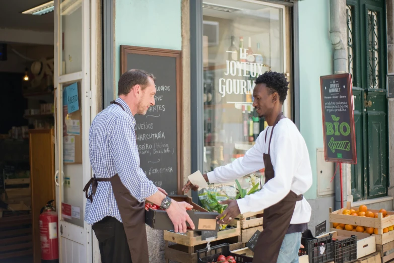 a couple of men standing next to each other in front of a store, by Jan Tengnagel, happening, local foods, profile image