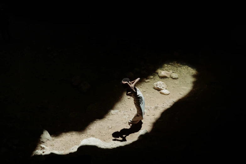 a man that is standing in the dirt, a cave painting, by Nathalie Rattner, unsplash contest winner, figuration libre, lights and shadows, 14 yo berber boy, medium format. soft light, a high angle shot