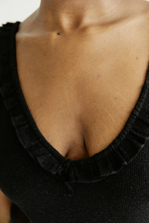 a close up of a woman wearing a black top, inspired by René Burri, renaissance, stomach skin, ( ( dark skin ) ), implants, detailed product image