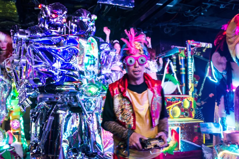 a group of people that are standing in front of a robot, maximalism, bright glowing instruments, drummer, kousuke oono, wearing disco suit