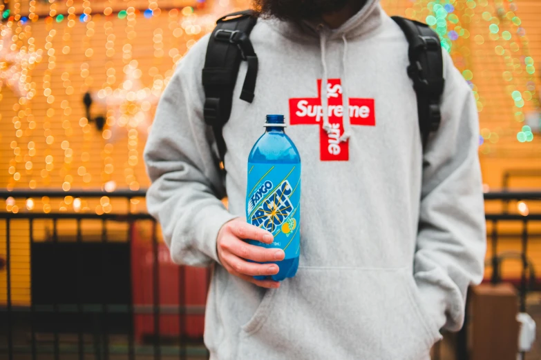 a man in a hoodie holding a bottle of water, by Julia Pishtar, featured on reddit, supreme, blue neon details, at a mall, rave otufit