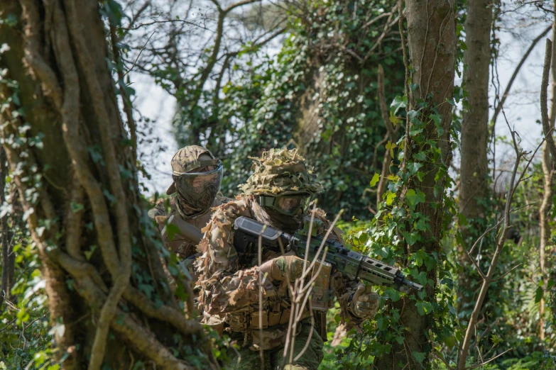 two soldiers in camouflage walking through the woods, by John Covert, shutterstock, 🕹️ 😎 🔫 🤖 🚬, environmental shot, gunfire, troops searching the area