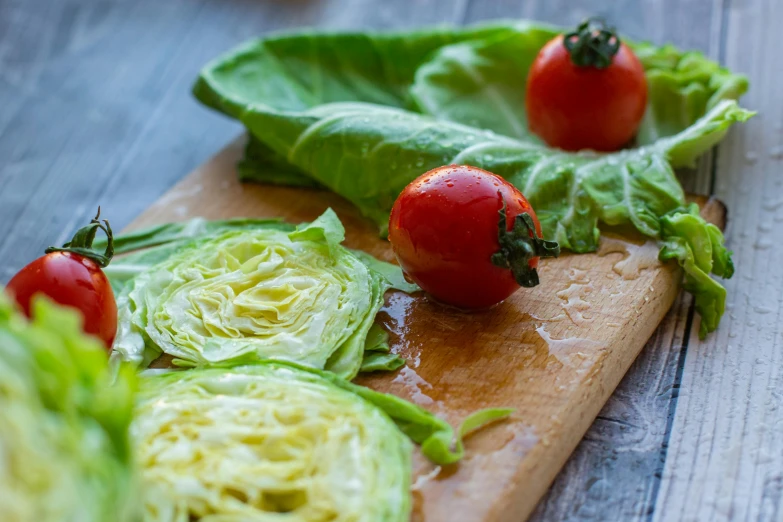 a wooden cutting board topped with lettuce and tomatoes, by Jessie Algie, romanticism, extra crisp image, fan favorite, intricate wrinkles, mediterranean