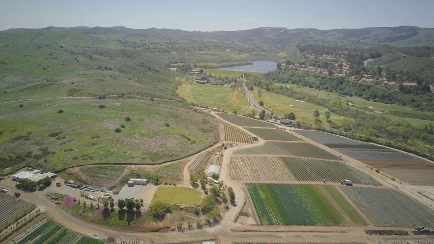 an aerial view of a farm with a lake in the distance, malibu canyon, hydroponic farms, contest winner 2021, photo from the dig site