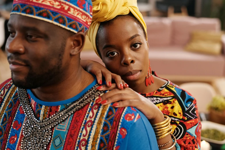 a man and a woman standing next to each other, a portrait, inspired by Ras Akyem, pexels, afrofuturism, wearing an african dress, netflix, red and blue garments, comforting