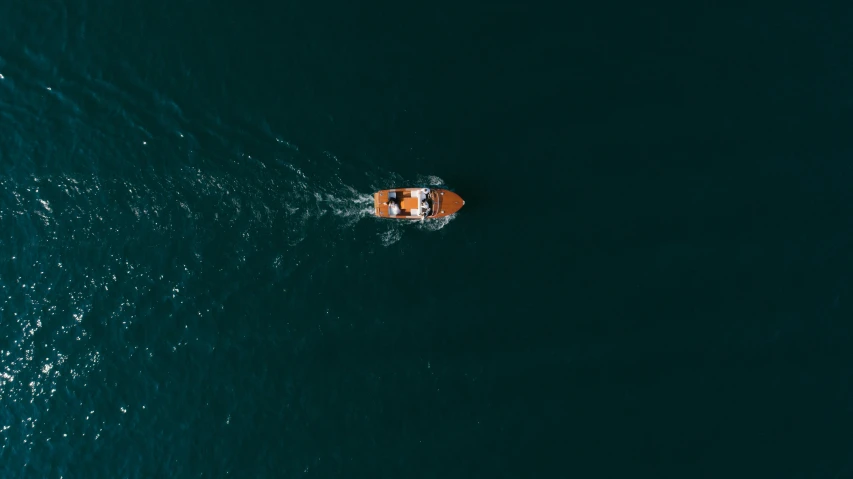 a small boat in the middle of a large body of water, pexels contest winner, top down camera angle, let's get dangerous, opening shot, deep colour