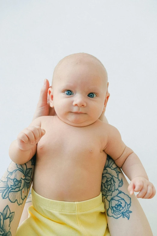 a woman holding a baby in her arms, a tattoo, trending on reddit, plain background, scientific photo, ultrawide image, hear no evil