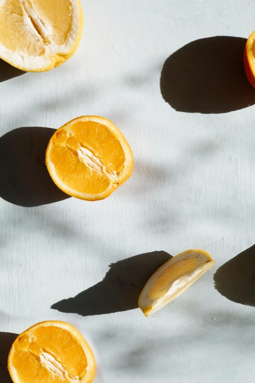 a group of oranges cut in half on a table, by Carey Morris, trending on pexels, photorealism, overexposed sunlight, vanilla, sleek round shapes, a high angle shot