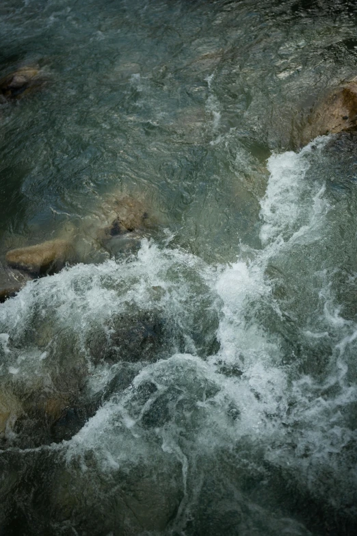 a man riding a surfboard on top of a wave in a river, inspired by Andreas Gursky, trending on unsplash, renaissance, wet rocks, photograph from above, made of water, babbling brook