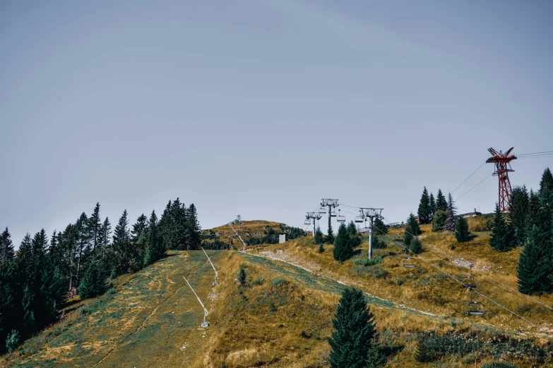 a ski lift going up the side of a hill, by Tobias Stimmer, pexels contest winner, les nabis, trees in the grassy hills, thumbnail, high quality image, conde nast traveler photo