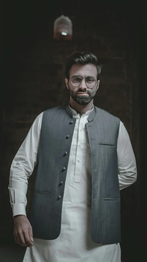 a man in a white shirt and grey vest, inspired by Osman Hamdi Bey, pexels contest winner, hurufiyya, dark backdrop, wearing a kurta, charlie cox, 15081959 21121991 01012000 4k