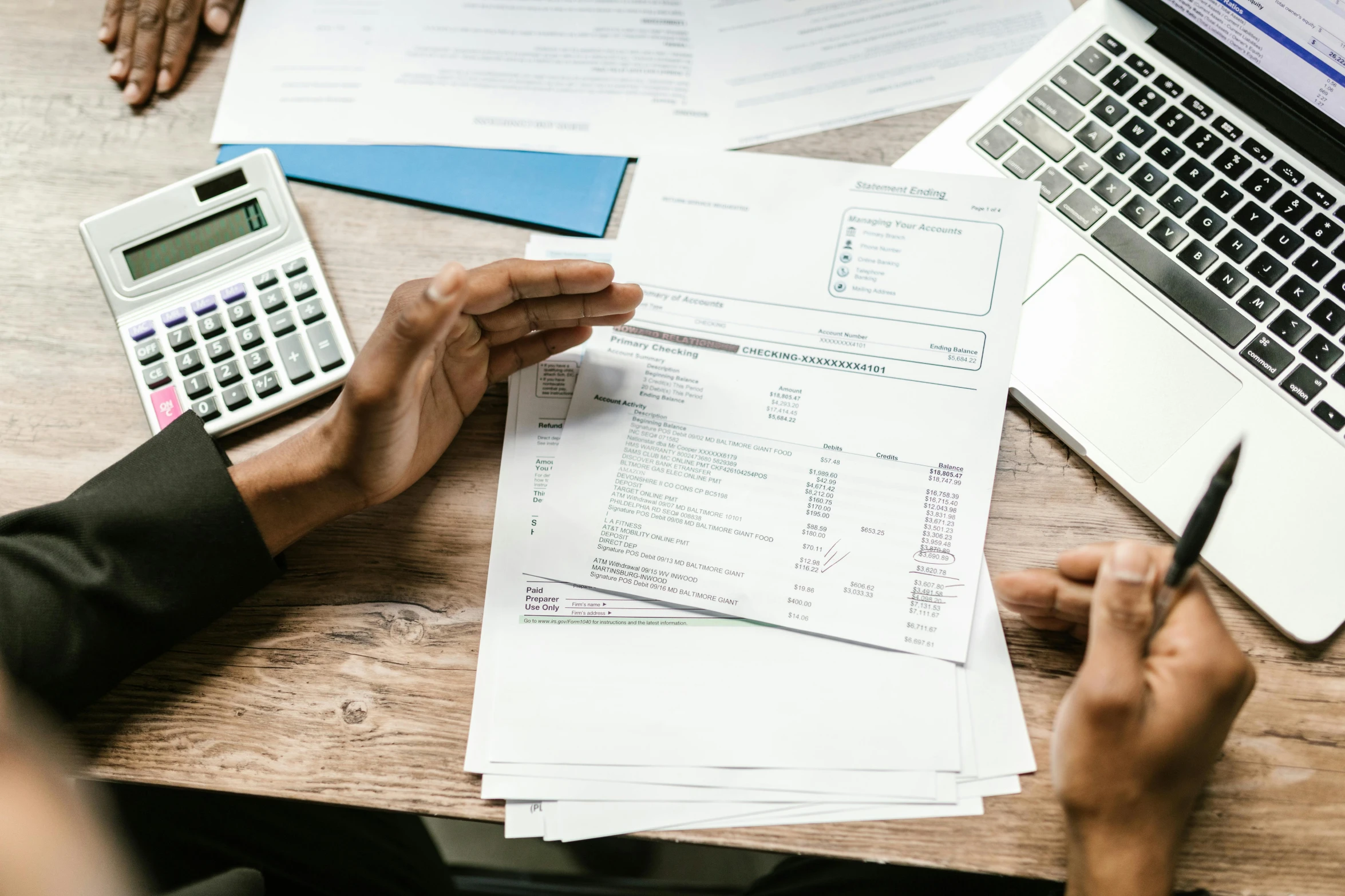 a person sitting at a table with papers and a calculator, a cartoon, pexels contest winner, hurufiyya, selling insurance, te pae, taking from above, split near the left