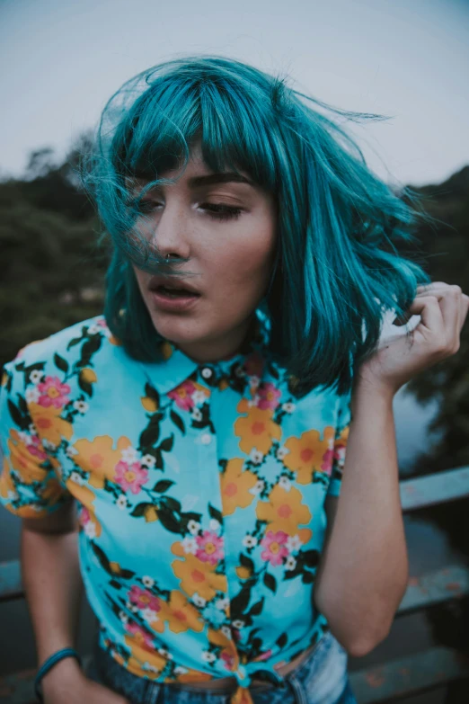 a woman with blue hair smoking a cigarette, inspired by Elsa Bleda, trending on pexels, floral clothes, in a dark teal polo shirt, electrified hair, lush vista