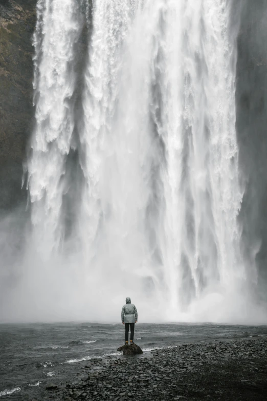 a person standing in front of a waterfall, by Matija Jama, pexels contest winner, visual art, human staring blankly ahead, is tall, wide full body, facing away from camera