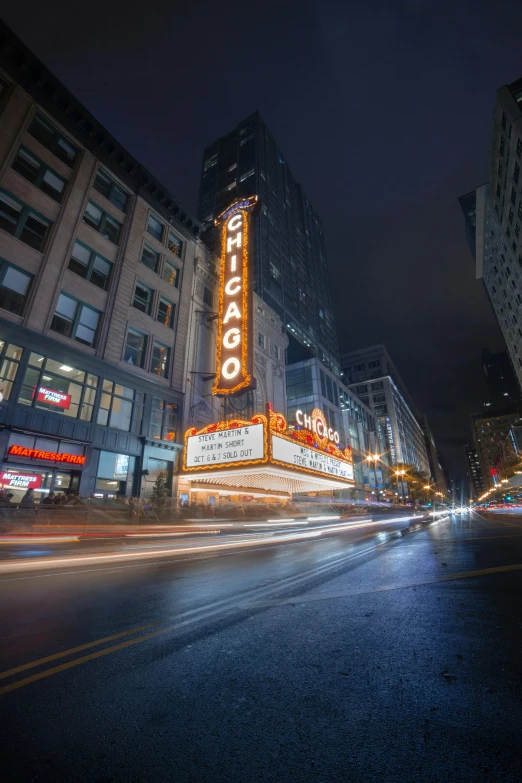 the chicago theater marquee is lit up at night, by Greg Rutkowski, unsplash contest winner, in 4k, city streetscape, charging through city, exterior view