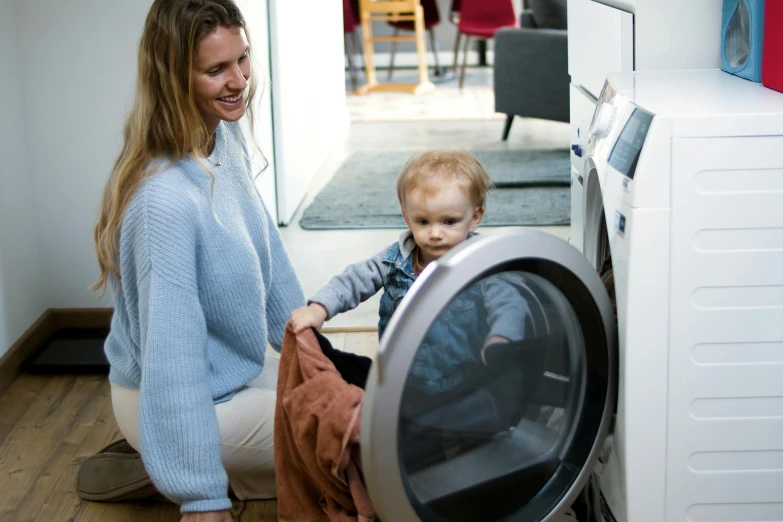 a woman and a child playing with a washing machine, pexels contest winner, “ iron bark, inspect in inventory image, profile image, small in size