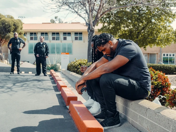 a man sitting on a curb next to a fire hydrant, an album cover, by Ryan Pancoast, pexels contest winner, police officers, : kendrick lamar, school class, disappointed