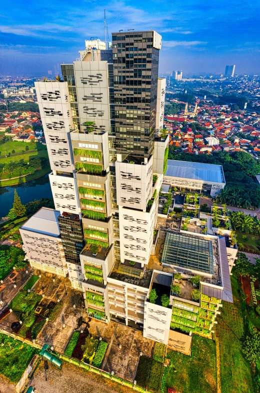 a tall building sitting on top of a lush green field, inspired by Erik Pevernagie, cg society contest winner, photorealism, indonesia national geographic, aerial photograph of skyscraper, modular, evening time