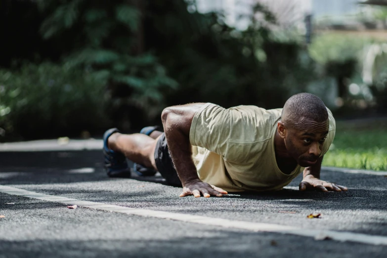 a man is doing push ups on the street, pexels contest winner, black man, background image, lying on the woods path, australian