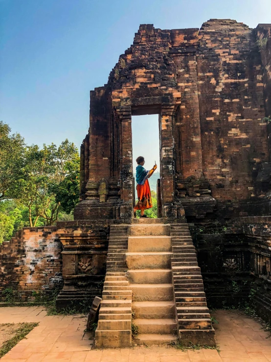 a couple of people that are standing in front of a building, temple ruins, nivanh chanthara, taking a picture, about to enter doorframe