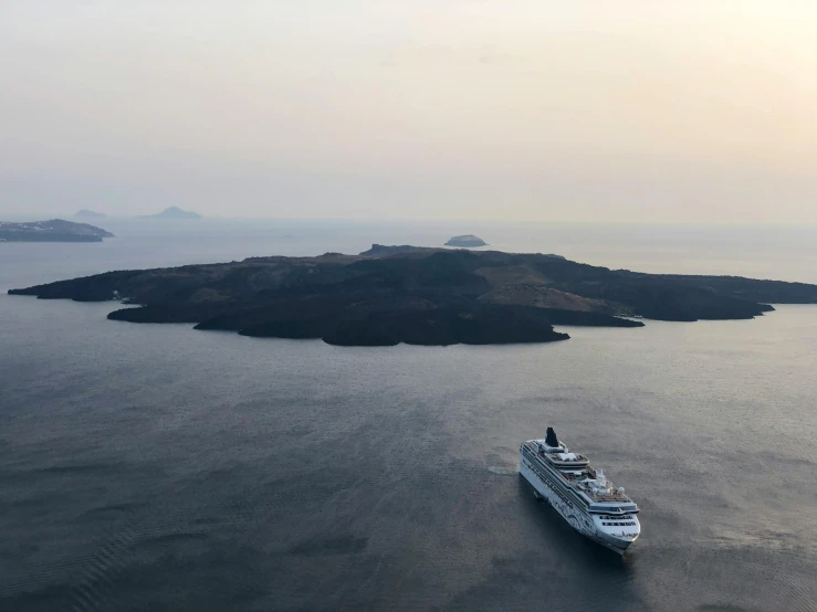 a large boat in the middle of a body of water, pexels contest winner, renaissance, an island made of caviar, greek setting, grey, setting sun