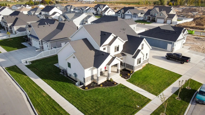 a group of houses sitting on top of a lush green field, by Ben Zoeller, white wall complex, listing image, utah, fully built buildings