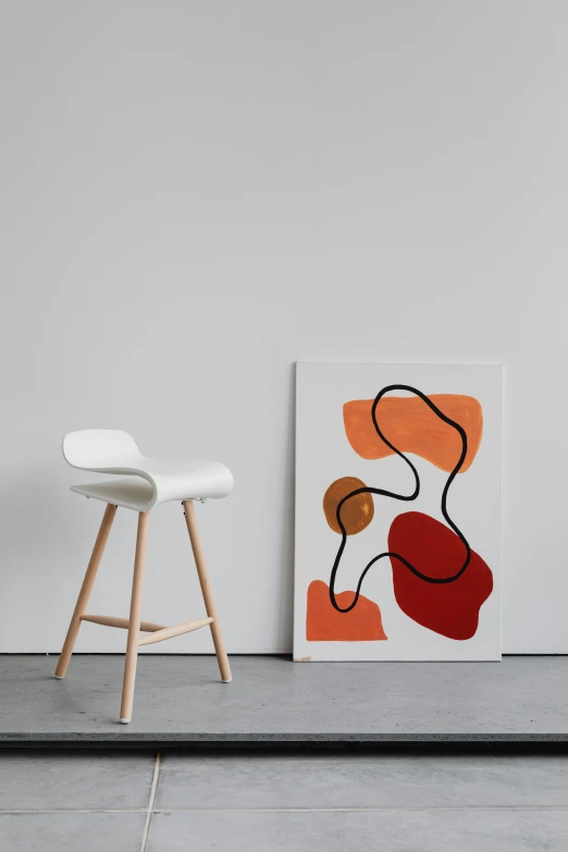 a white chair sitting next to a painting on a wall, poster art, inspired by Jean Arp, unsplash contest winner, stools, light red and orange mood, product view, enamel