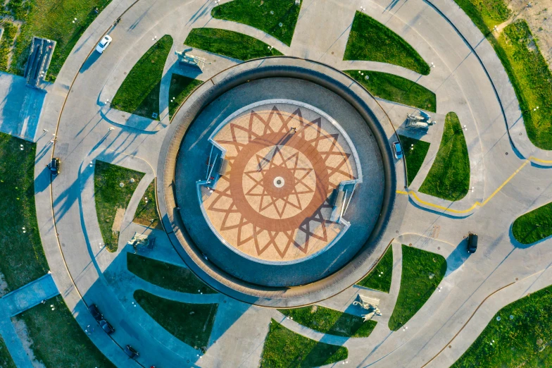 an aerial view of a circular fountain in a park, a mosaic, by Dan Content, pexels contest winner, soviet architecture, shipibo, center of sky, from wheaton illinois