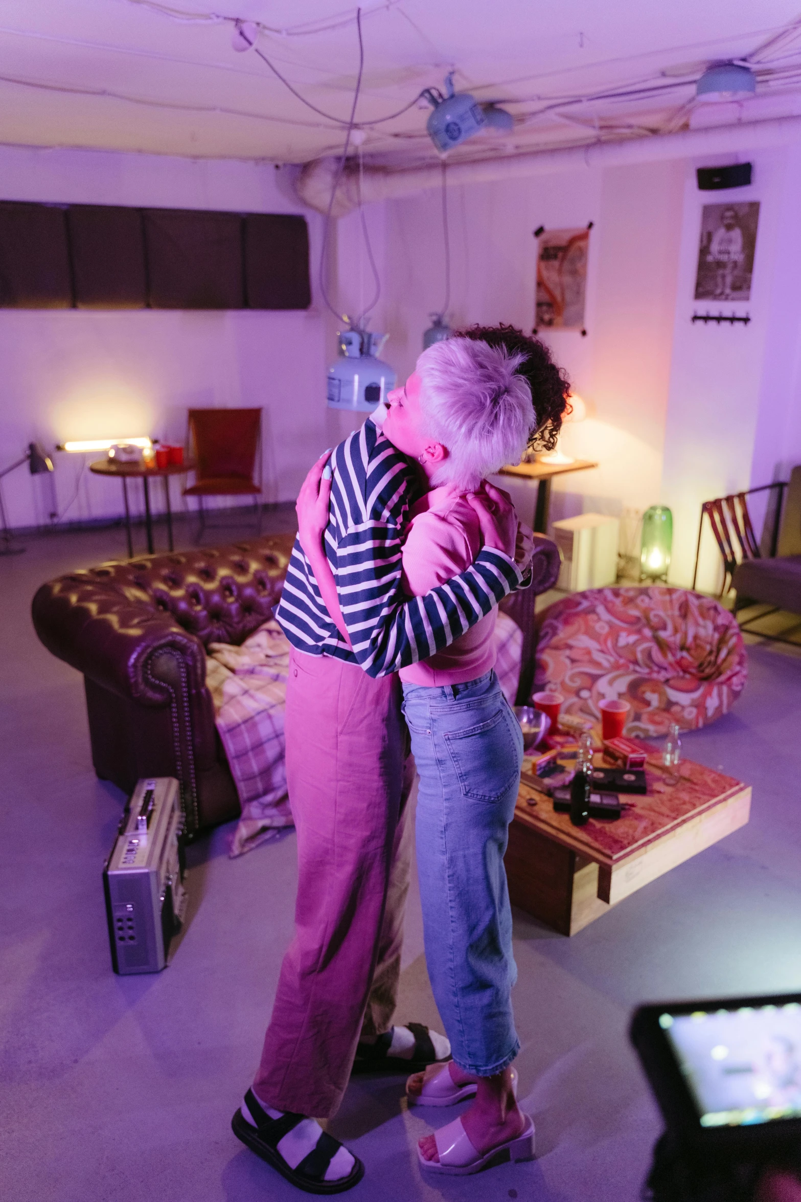 a couple of people that are standing in a room, by Liza Donnelly, lesbian embrace, purple scene lighting, charli bowater and artgeem, in a living room