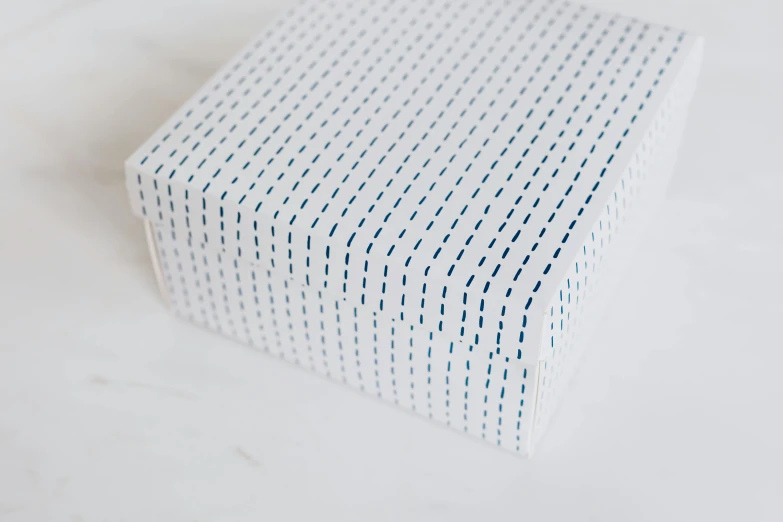 a close up of a box on a table, by Shigeru Aoki, unsplash, kinetic pointillism, lined in cotton, blue soft details, on white background, square lines