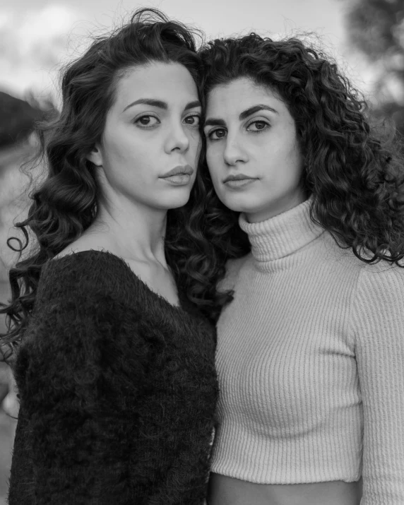 a couple of women standing next to each other, a black and white photo, inspired by irakli nadar, curls on top, meni chatzipanagiotou, color photograph portrait 4k, greek ameera al taweel
