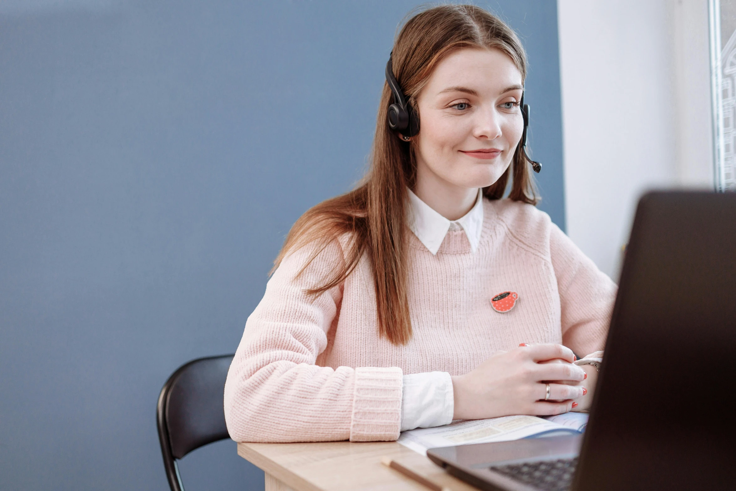 a woman sitting in front of a laptop wearing a headset, trending on pexels, danube school, avatar image, wearing a pastel pink hoodie, girl wearing uniform, professional detailed photo